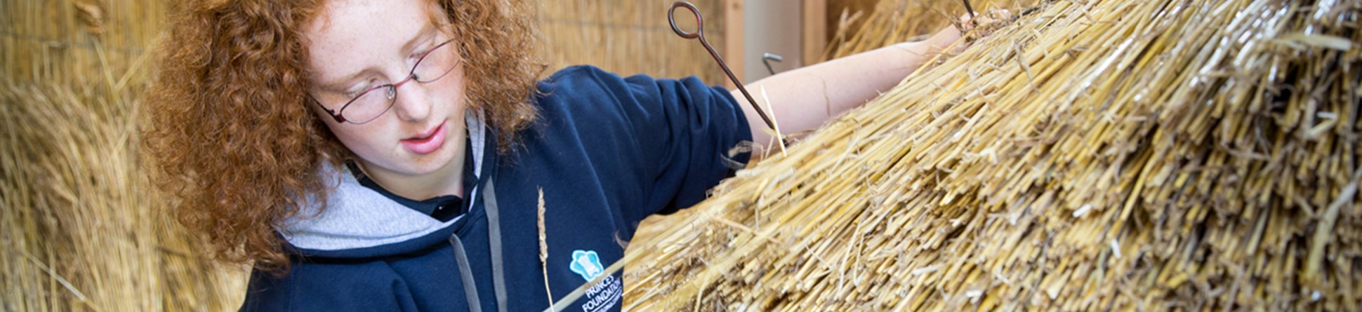 an image of Prince's Foundation trainee Miriam Johnson, learning traditional methods of thatching, as part of her bursary placement on the Building Craft Programme