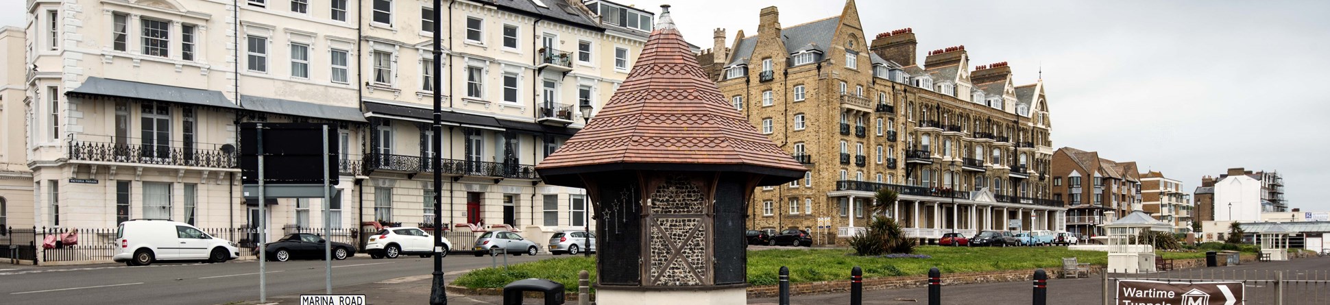 Timber framed octagonal kiosk on Ramsgate seafront with terrace of buildings in the background