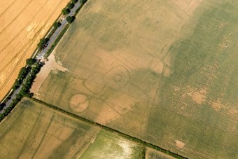 Traces of a prehistoric settlement revealed as cropmarks in an aerial photograph.
