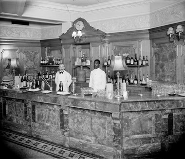 Barmen standing behind the Long Bar at the Trocadero