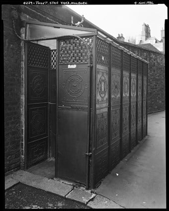 The exterior of the decorative cast iron urinal building, constructed in the form of a ‘lean-to’ structure with the entrance seen in the foreground.