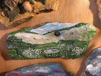 A fragment of stone roof tile reused by a 21st -century artist to depict a local landscape.