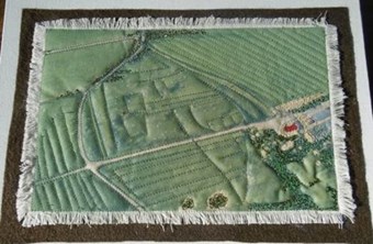 A textile quilt produced by a 21-st century artist inspired by a medieval landscape seen in an aerial photograph