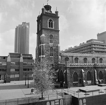 A black and white photo showing St Giles church from the South side, with a tower block in the background.