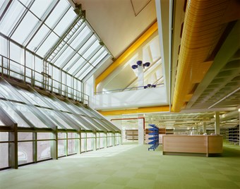 An interior image of the newly opened Carlisle Library featuring large glass windows, pale green carpet and bright yellow air condition ducting