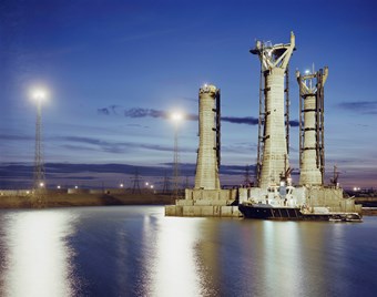 Sunset blue skies with lights reflecting on the water at Graythorp powerstation.