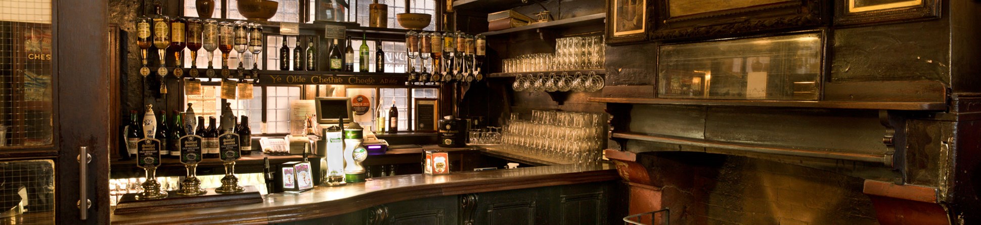 An interior detail of a bar area and fire place within a historic London public house.