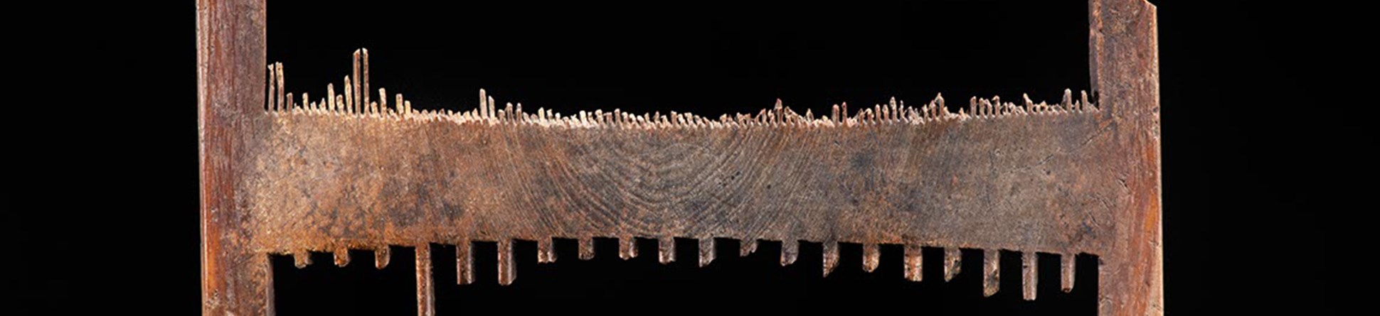 A nit comb which is has lost most of the teeth. The remnants of the teeth show how one side would have been fine-toothed, and the other side had wider spread teeth.