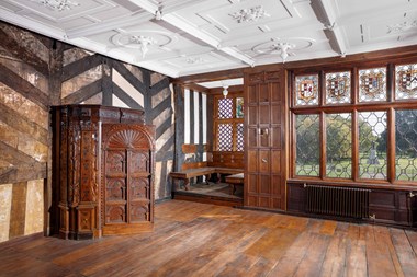 Interior, first floor, east elevation, Withdrawing Room post restoration/ conservation work following the arson attack in March 2016. View showing doorway to north, wooden panelling, ceiling, medieval heraldic glass and statue to Oliver Cromwell in grounds beyond.