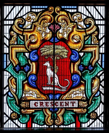 Medieval stained glass window including a central depiction of a greyhound tied up to a tree. Approximately two foot high. Includes the word 'CRESCENT' in the lower quarter