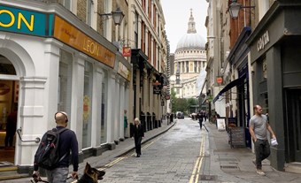 View west down narrow London street towards St Paul's Cathedral dome.