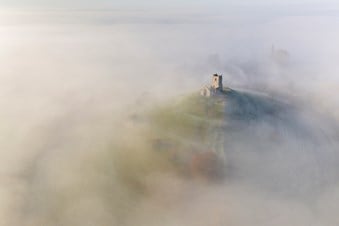 Aerial photograph of St Michael’s Church, Burrow Mump in Somerset mist covering surrounding area