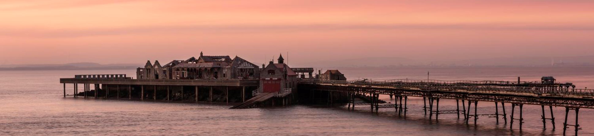 A photograph of a pier at sunset. 