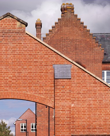 Details of a brick archway and a stepped gable behind it.
