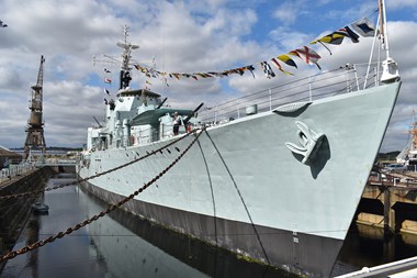 Destroyer in dock with bunting flying from its mast