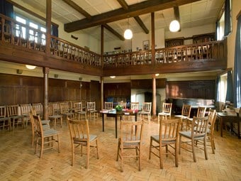 Meeting room with a gallery. Chairs are arranged in a circle around a table
