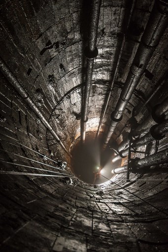 View down a mineshaft with a light shining from a person helmet