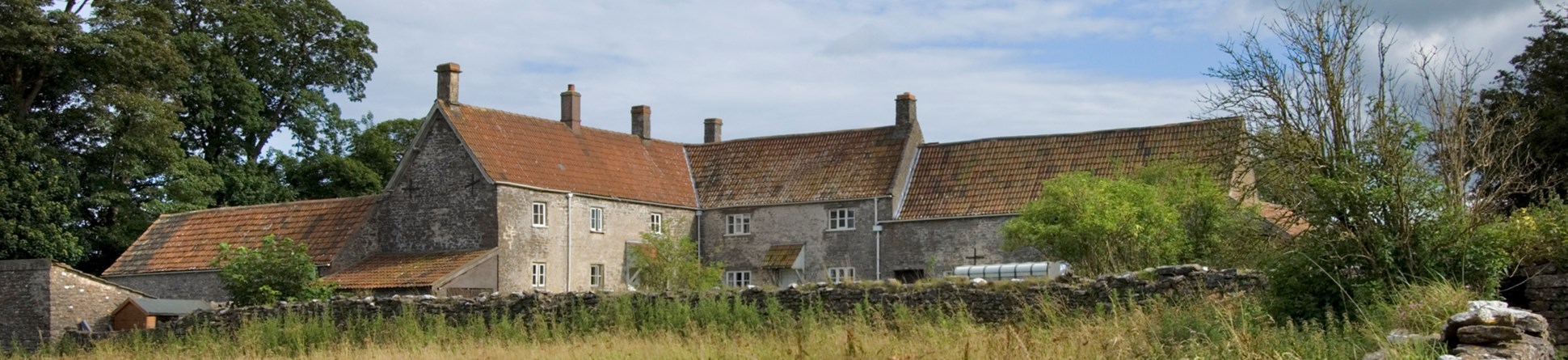 L-shaped stone farmstead in rural setting in Priddy, Somerset