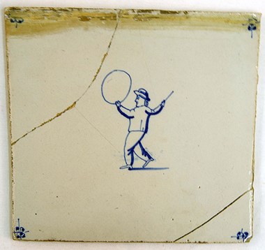 Dating to the early 17th century, this blue and white hand painted tile shows a boy playing with a hoop.