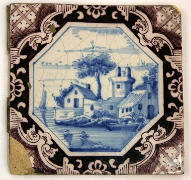 A mid 18th century tile depicting a water-side scene in blue and white, set inside a purple and white octagonal border removed from Brooke House. 