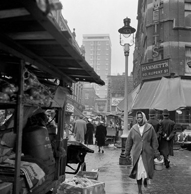 People walking past market stalls in Rupert Street, Soho