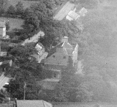A very grainy 1928 black and white image is the only surviving image of The Oaks, a grand house that was demolished in the 1930s. The house can be seen, surrounded by large trees and landscaped grounds.
