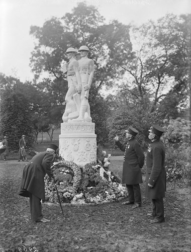 Old soldier laying a wreath on a war memorial