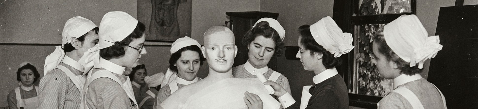 Student nurses learning how to bandage on a life size dummy