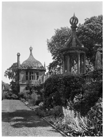 archive black and white photograph of a garden border with a summerhouse and lodge built into the garden wall