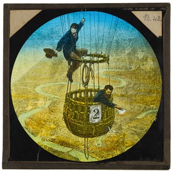 A hand-coloured slide showing an engraving of two men in a balloon flying over London