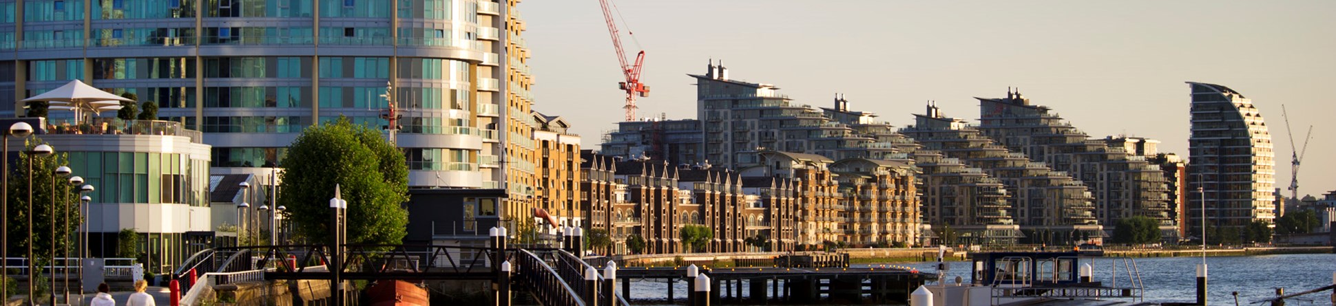 Riverside view of modern buildings under construction.