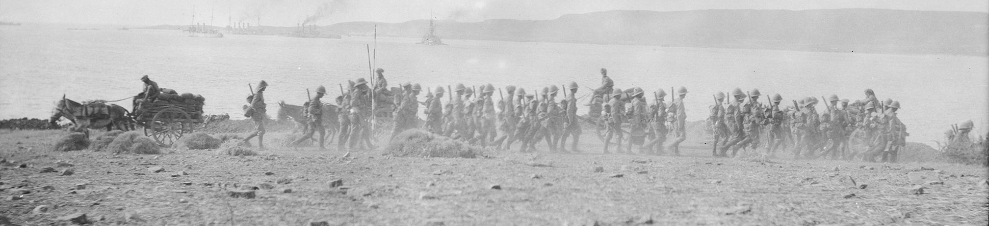 Black and white image of British troops walking on on a beach in Gallipoli, Turkey