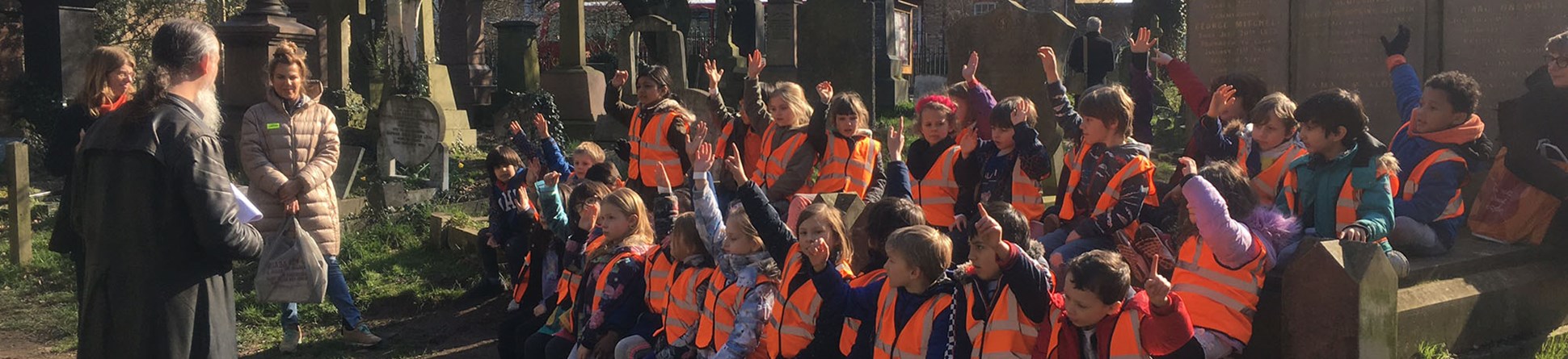 Children wearing high viz jackets gathered in Abney Park