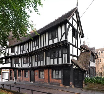 Old black and white timber-framed building except for red brick ground floor.