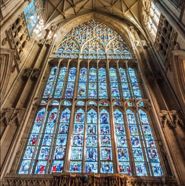 A huge stained glass window with gothic stone tracery.