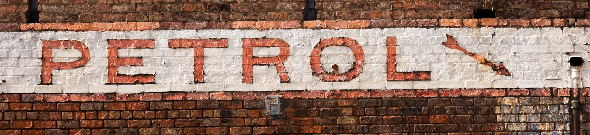 Image of a white and red sign reading 'petrol' on the front of a brick building
