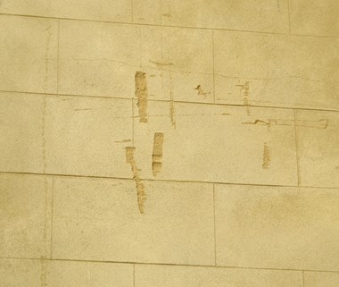 A wall with several deep gouges in the render.