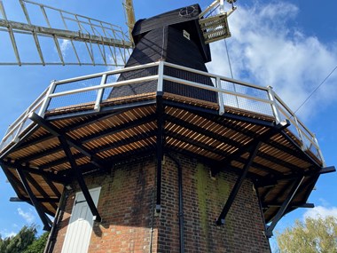 Photograph of the windmill from the base of the structure. The photo looks up to the newly refurbished oak decks,