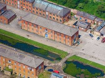 Rows of large red brick buildings separated by a canal.
