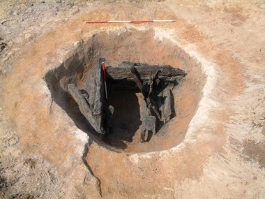 Photograph showing a timber structure at the base of an excavated pit.