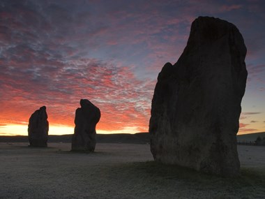 Neolithic Stones with the sun setting behind them.
