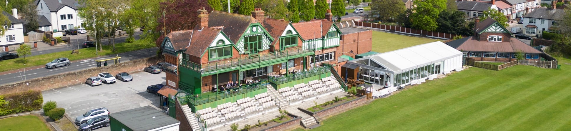 A cricket pavilion and the edge of the cricket pitch as viewed from above