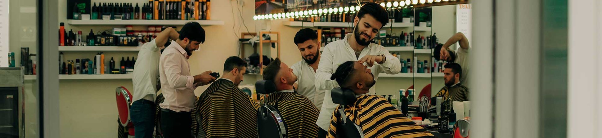 Men having shaves and their hair cut in a barbershop.