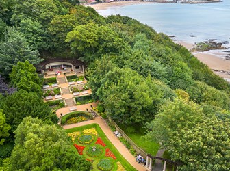 View of gardens beside a beach from above. 