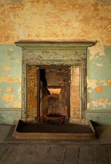 An old patinated fireplace in distressed surroundings.