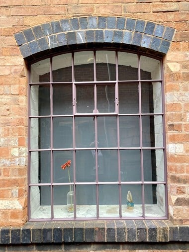 Up close photograph of Newman Brothers' Coffin Works, with a restored window frame and new glass panes. 